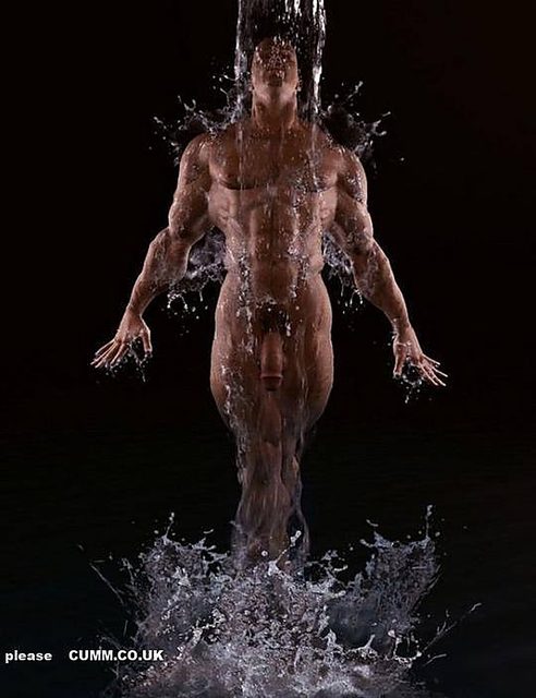 A highly muscular nude man stands centered against a dark background as water pours down over his body and splashes at his feet.